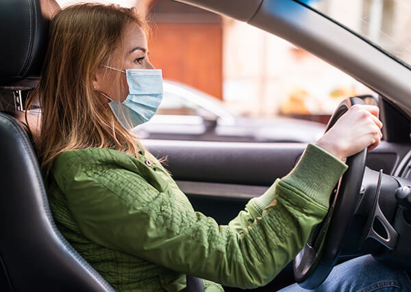 Žena sa medicinskom maskom vozi auto